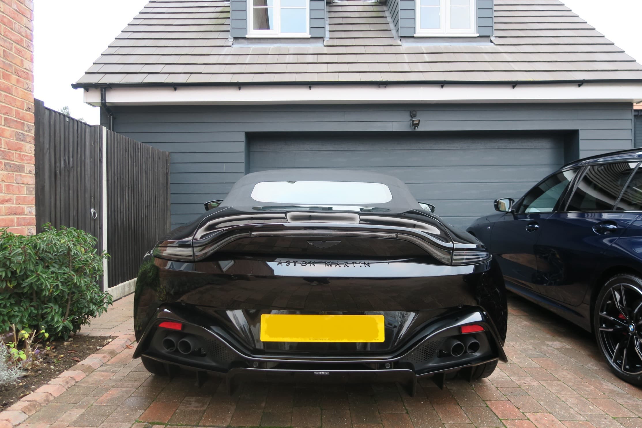Black Aston Martin convertible on a driveway