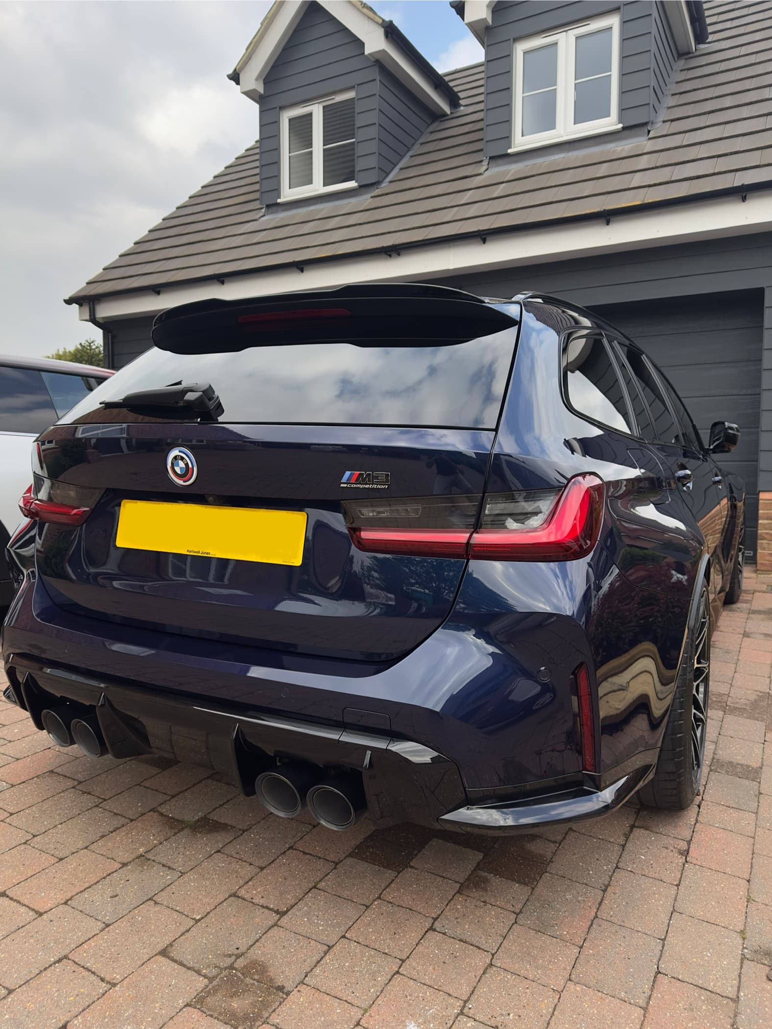 Navy BMW M3 Competition Touring on a driveway