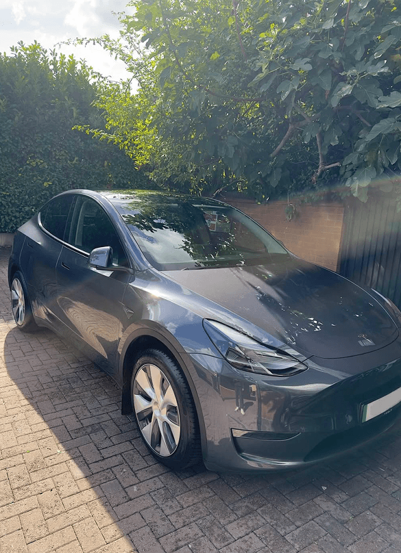 Grey Tesla Model Y on a brick driveway